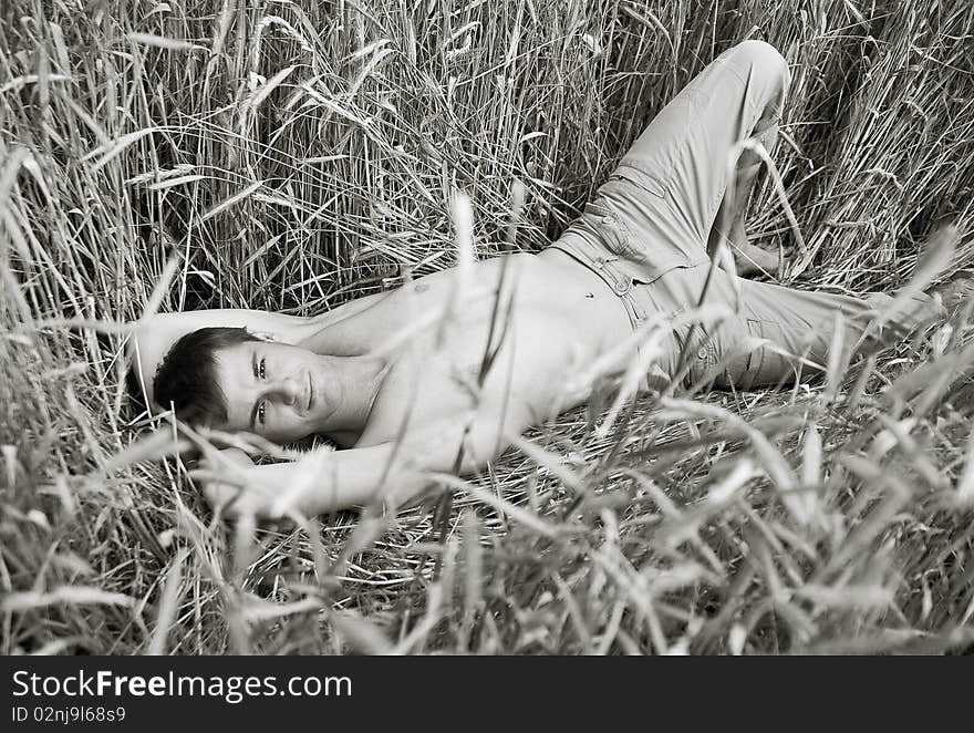 A man lie in field of wheat. black-and-white photo