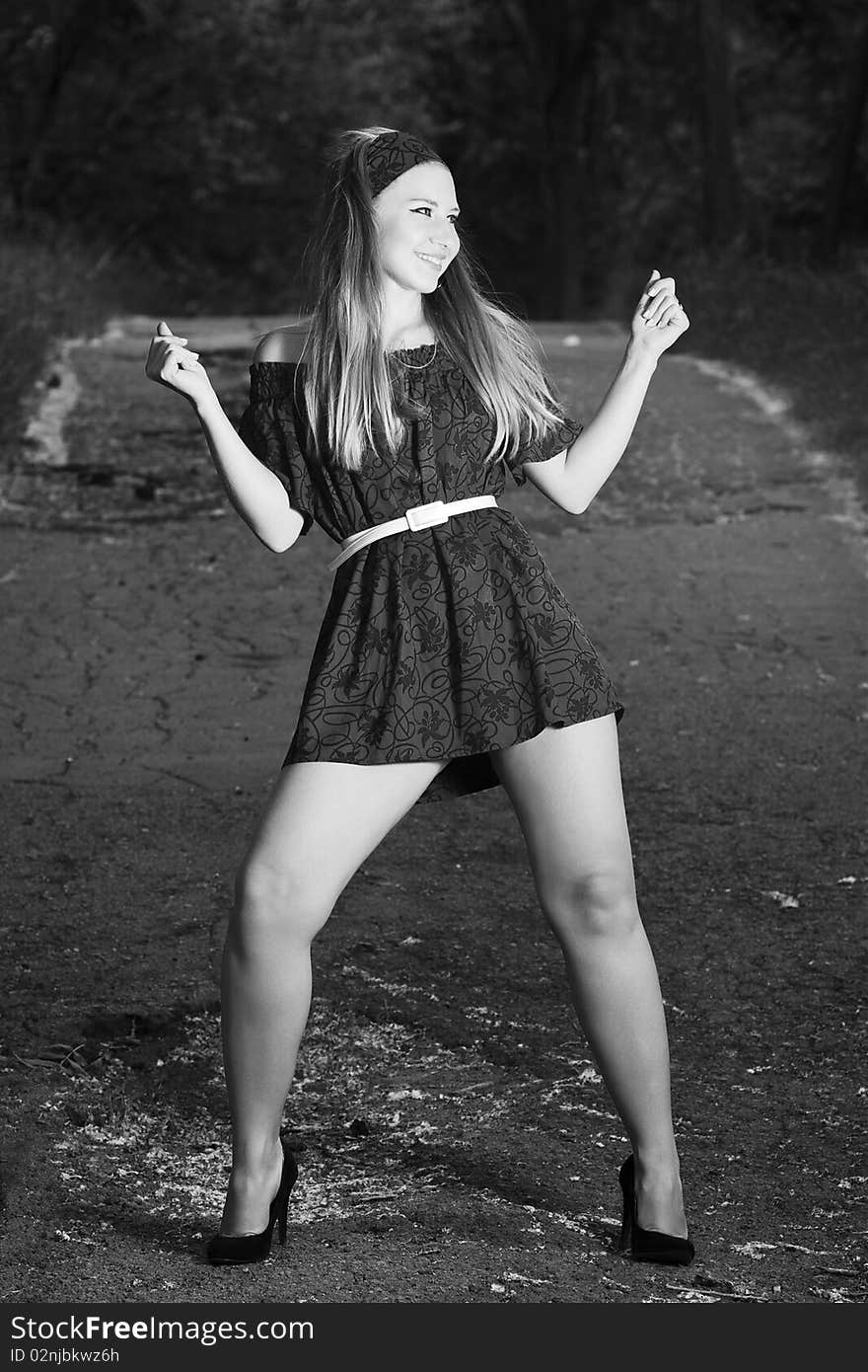 Smiling young woman in dress posing