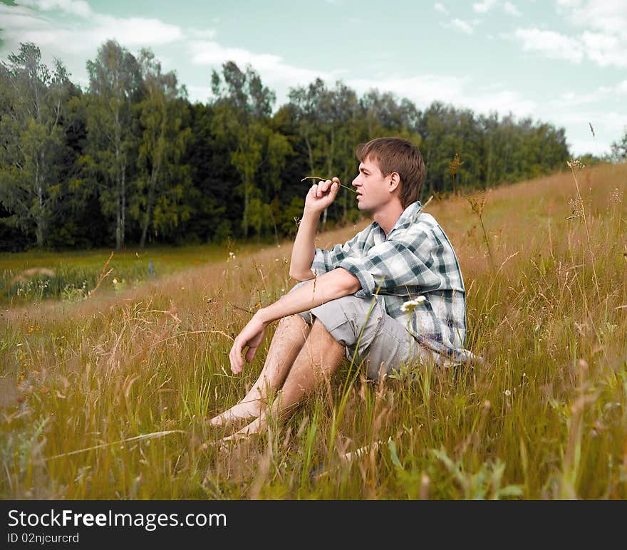 Pretty men sit on a meadow. Pretty men sit on a meadow