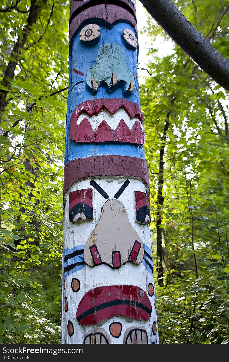 A colorful totem pole in the forest.