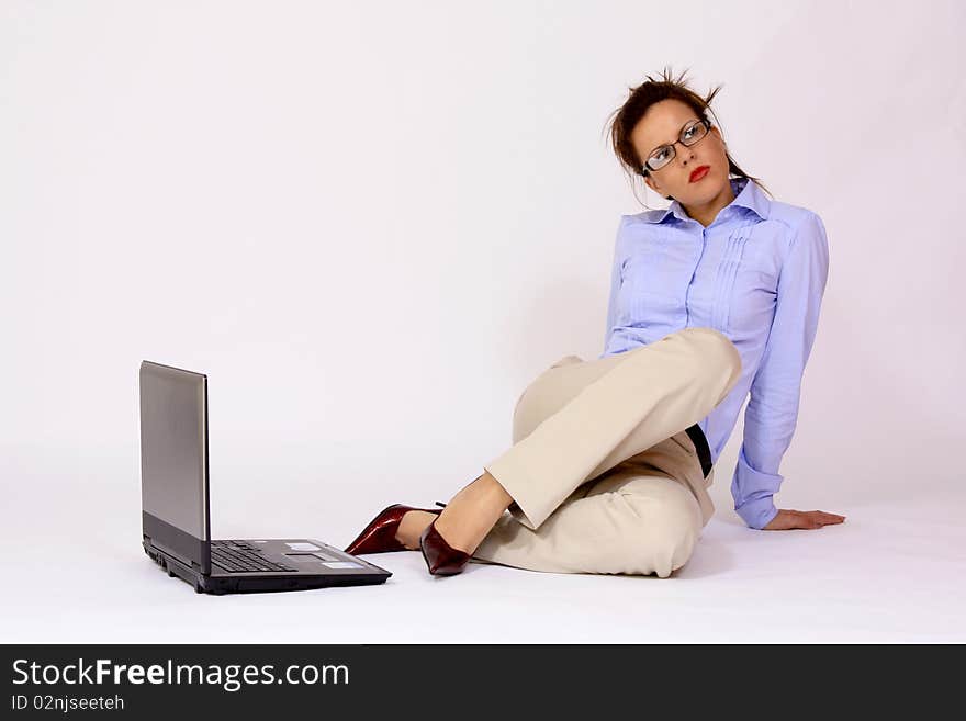 Girl with eyeglasses sitting by the lap top