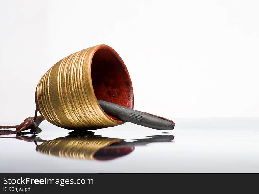 Clay bell hand made lying on reflective surface. Clay bell hand made lying on reflective surface