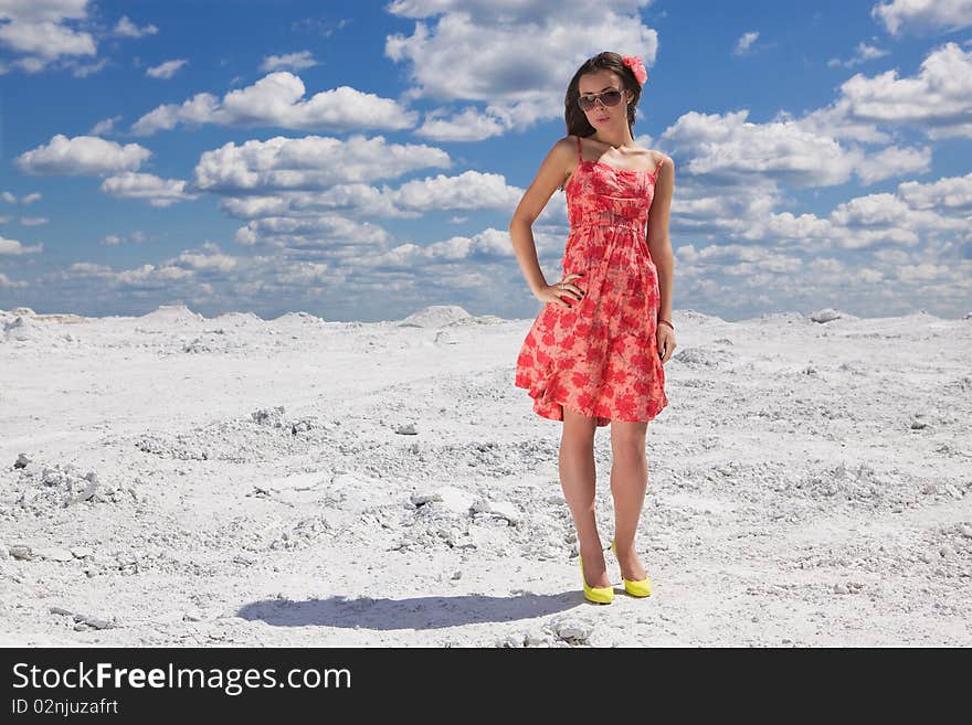 Cute young woman in red dress on the snow