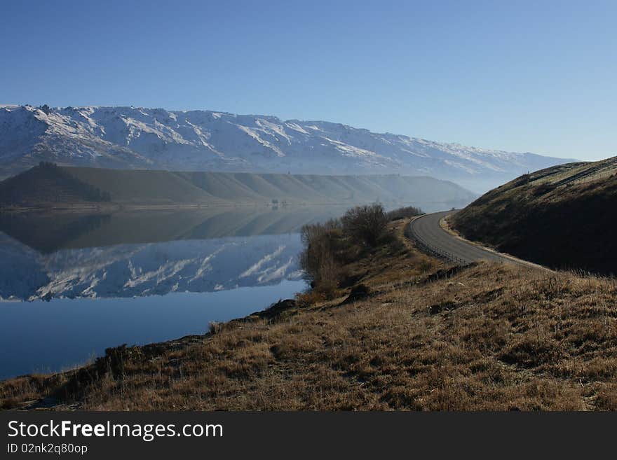 The road running beside Lake Dunstan, on a windless and cold morning. The road running beside Lake Dunstan, on a windless and cold morning.