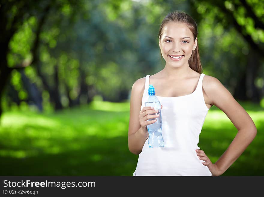 A beautiful girl with a bottle of water in the park