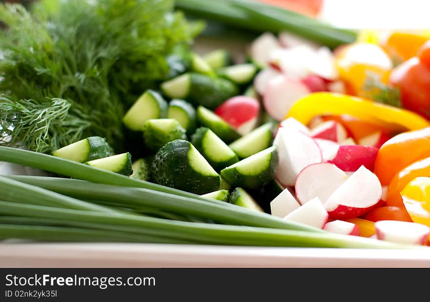 Multi-colored fresh vegetables, cut, on a plate