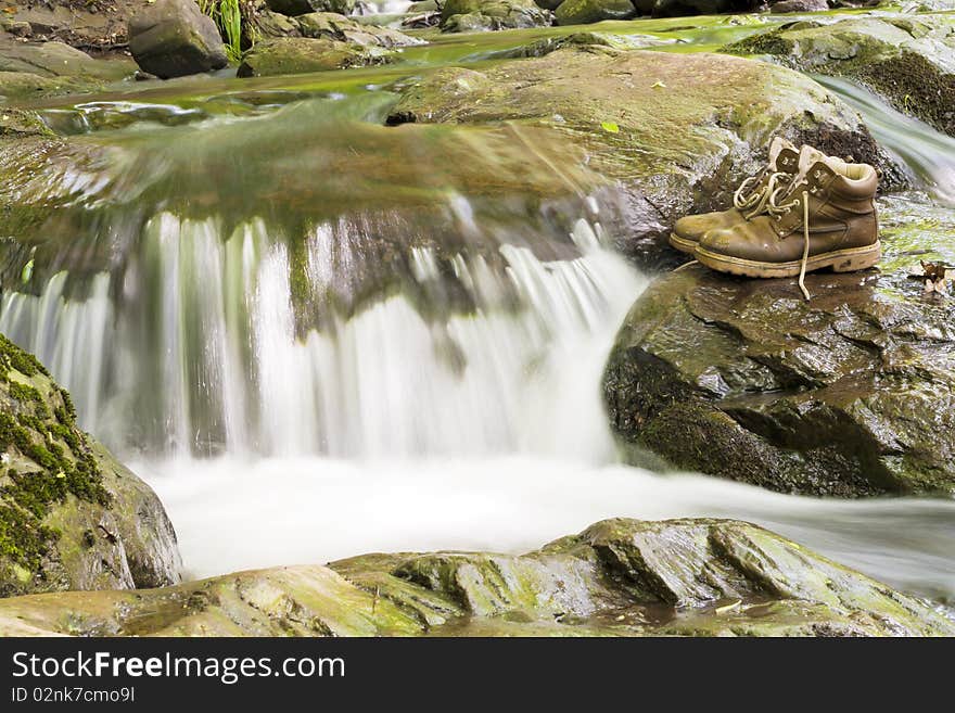 A pair of hiking boots at the waterfall.