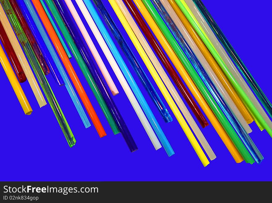 Glass sticks of different colours on a dark blue background