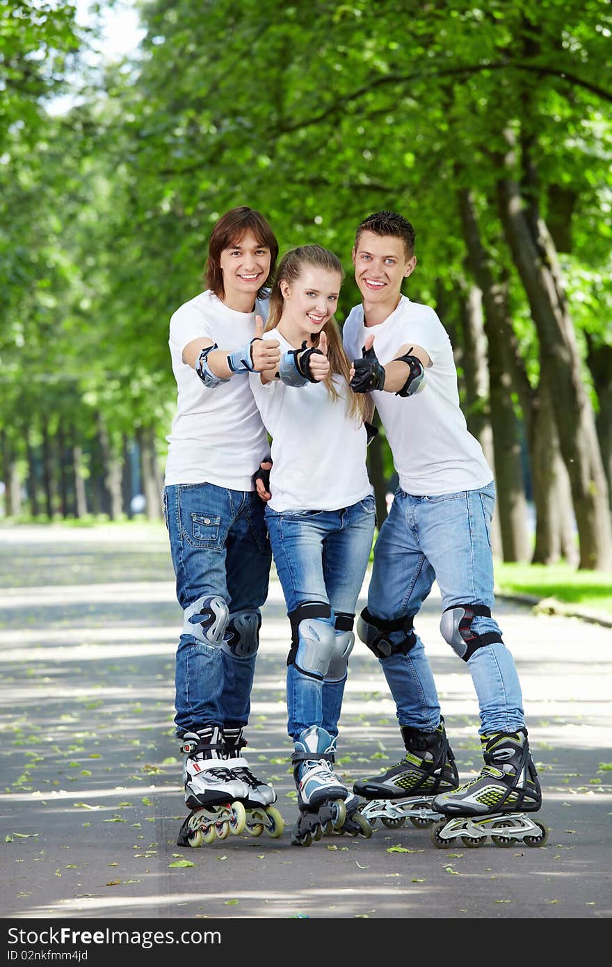 Three young people on the rolls show a big thumbs up. Three young people on the rolls show a big thumbs up