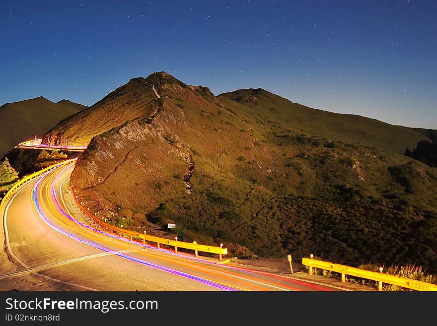 Traffic light on a mountain road at starry night. Traffic light on a mountain road at starry night