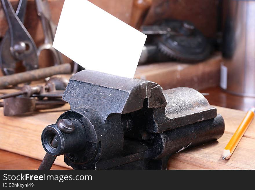 Business card in a metalwork vice for placing on it the necessary information.