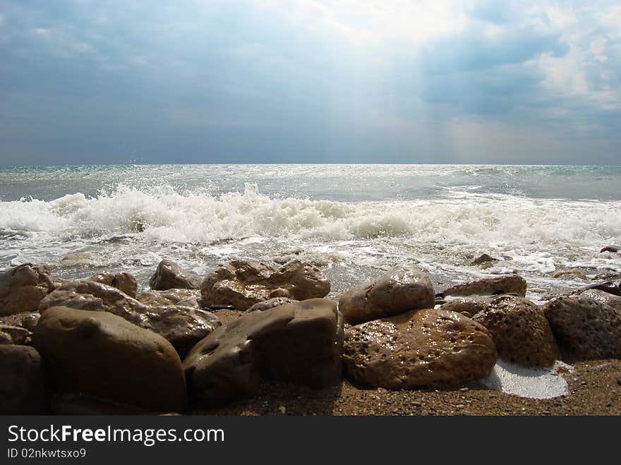 View of a stormy sea with a big stones on the coastline. View of a stormy sea with a big stones on the coastline