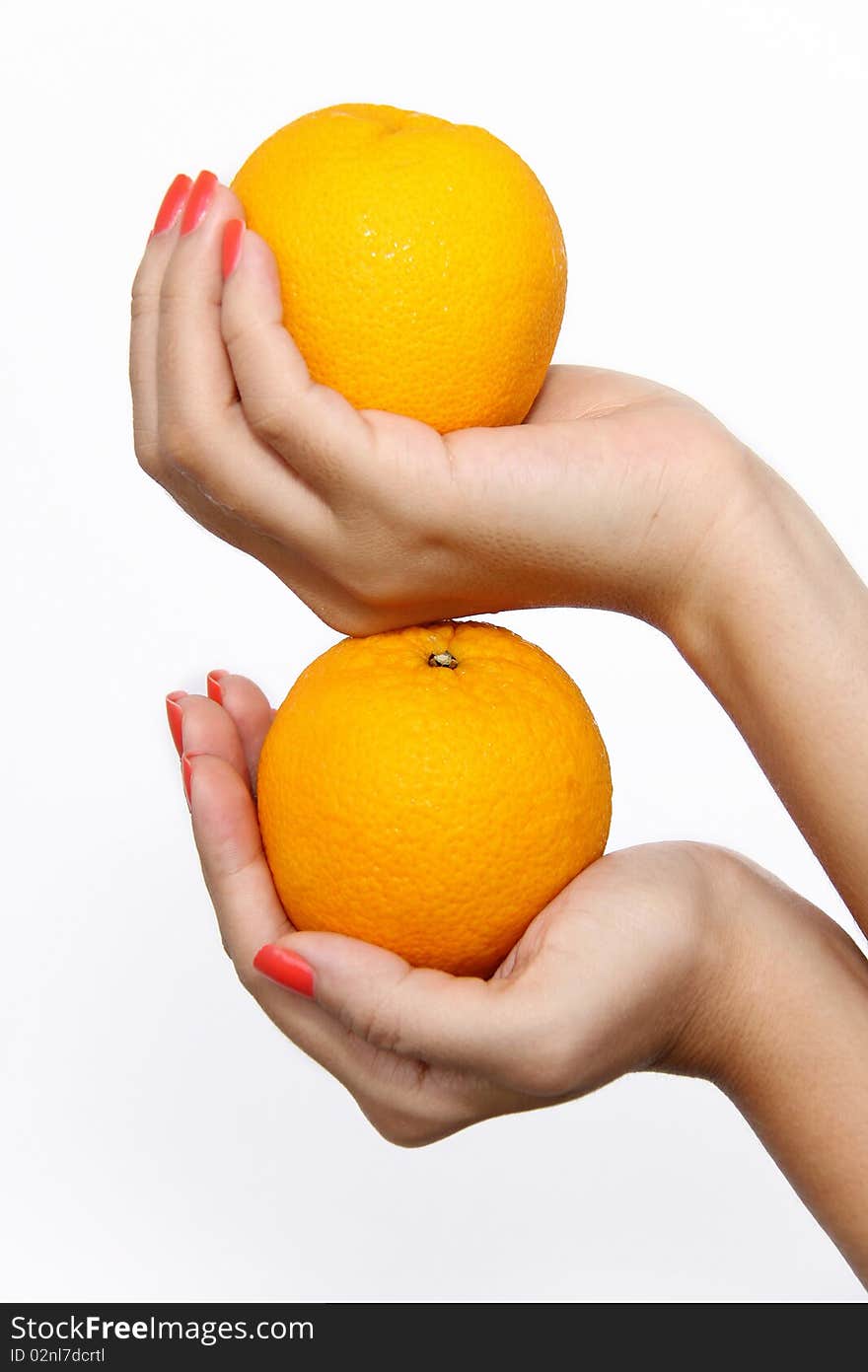 Two hands holding oranges stacked on top of each other. On solid white background. Two hands holding oranges stacked on top of each other. On solid white background.