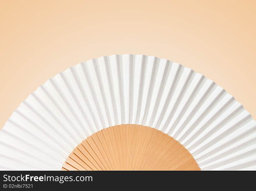 Folding fan isolated on a yellow background.