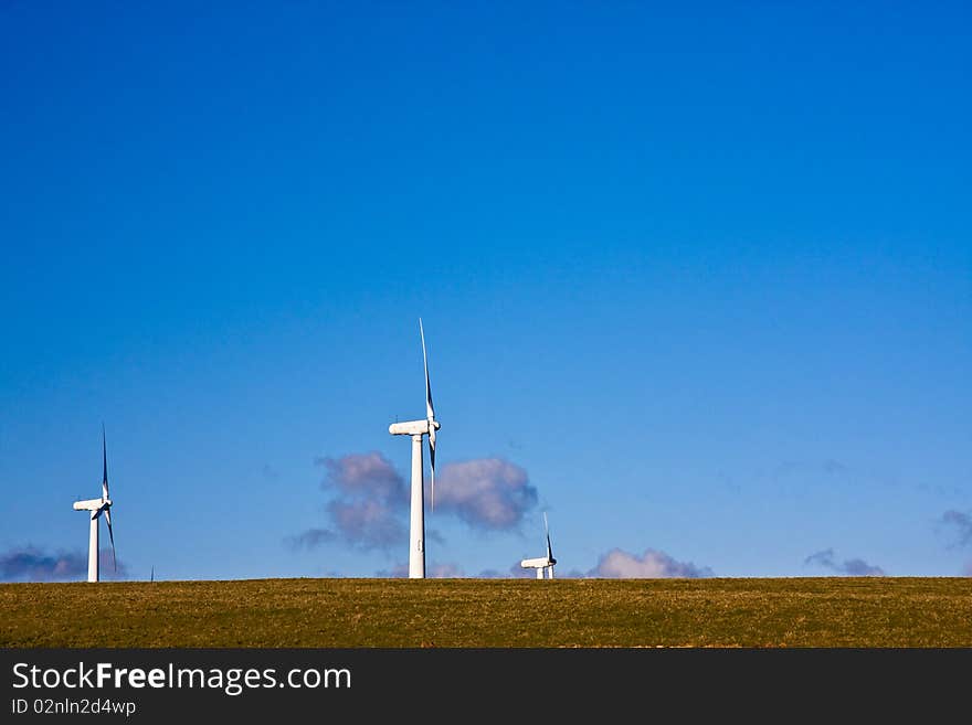 Cornwall's green energy solution are wind turbines on the horizon with a clear blue sky