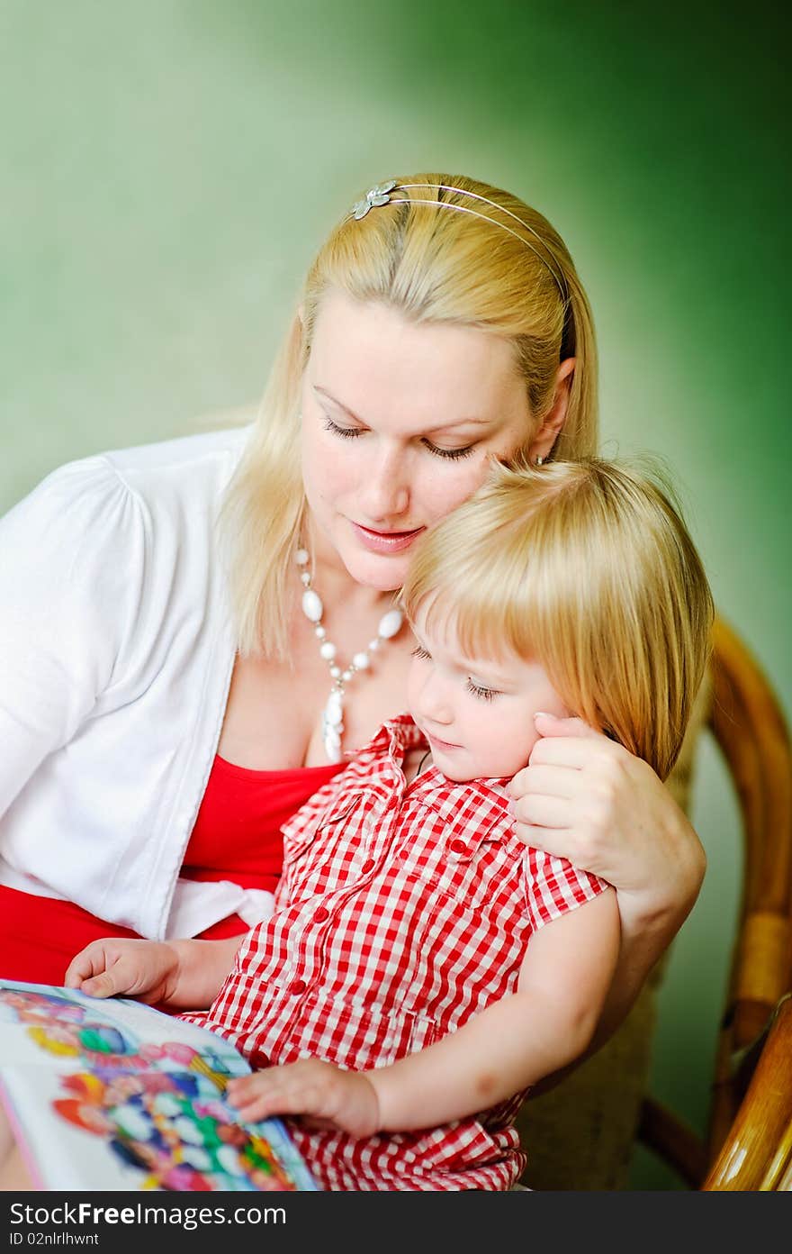 Mother and daughter sit and read the books and tell fairy tales. Mother and daughter sit and read the books and tell fairy tales