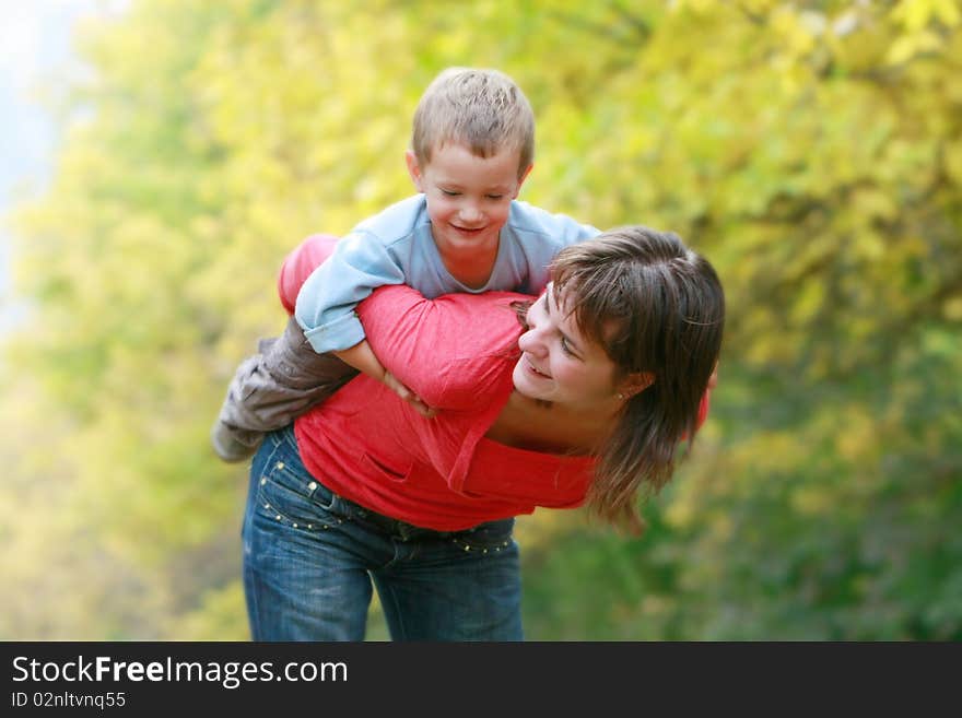 Happy mother playing with son outdoors