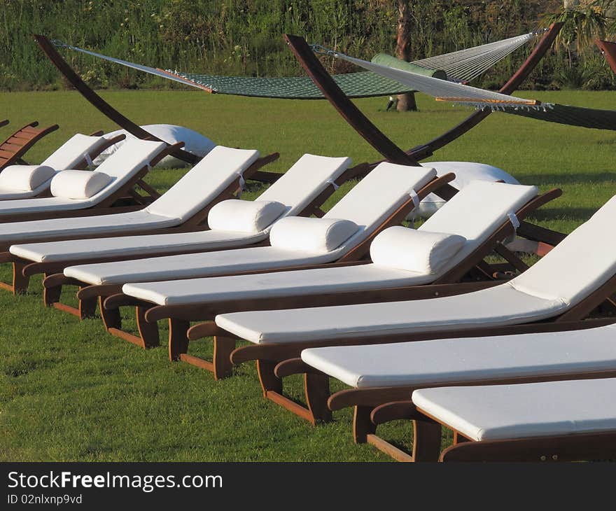 Lounge beds and hammocks at the beach of resort hotel