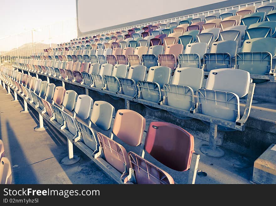 Old faded Stadium Seats on a row. Old faded Stadium Seats on a row