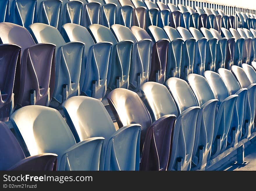 Rows of old faded Stadium Seats. Rows of old faded Stadium Seats