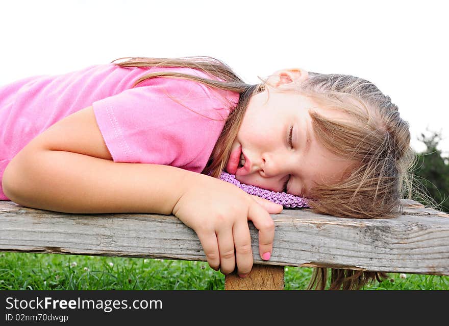 Girl sleeping on a bench in the nature of