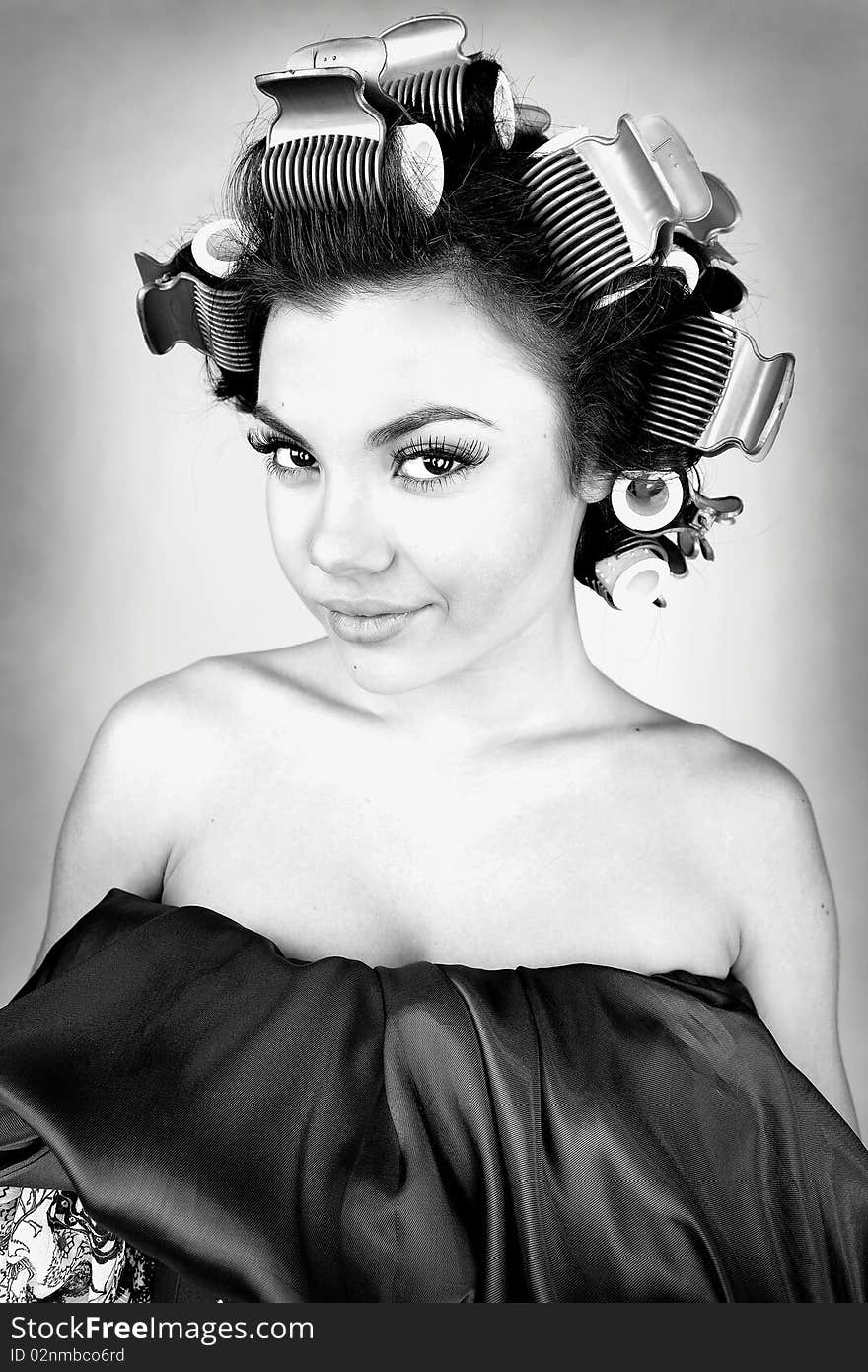 Emotional Girl with hair-curlers on her head. Photo.