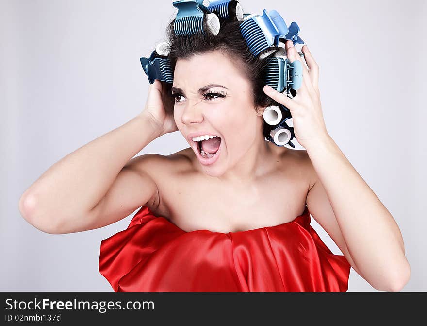 Emotional Girl with hair-curlers on her head. Photo.