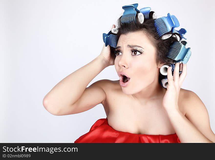 Emotional Girl with hair-curlers on her head. Photo with copyspace.