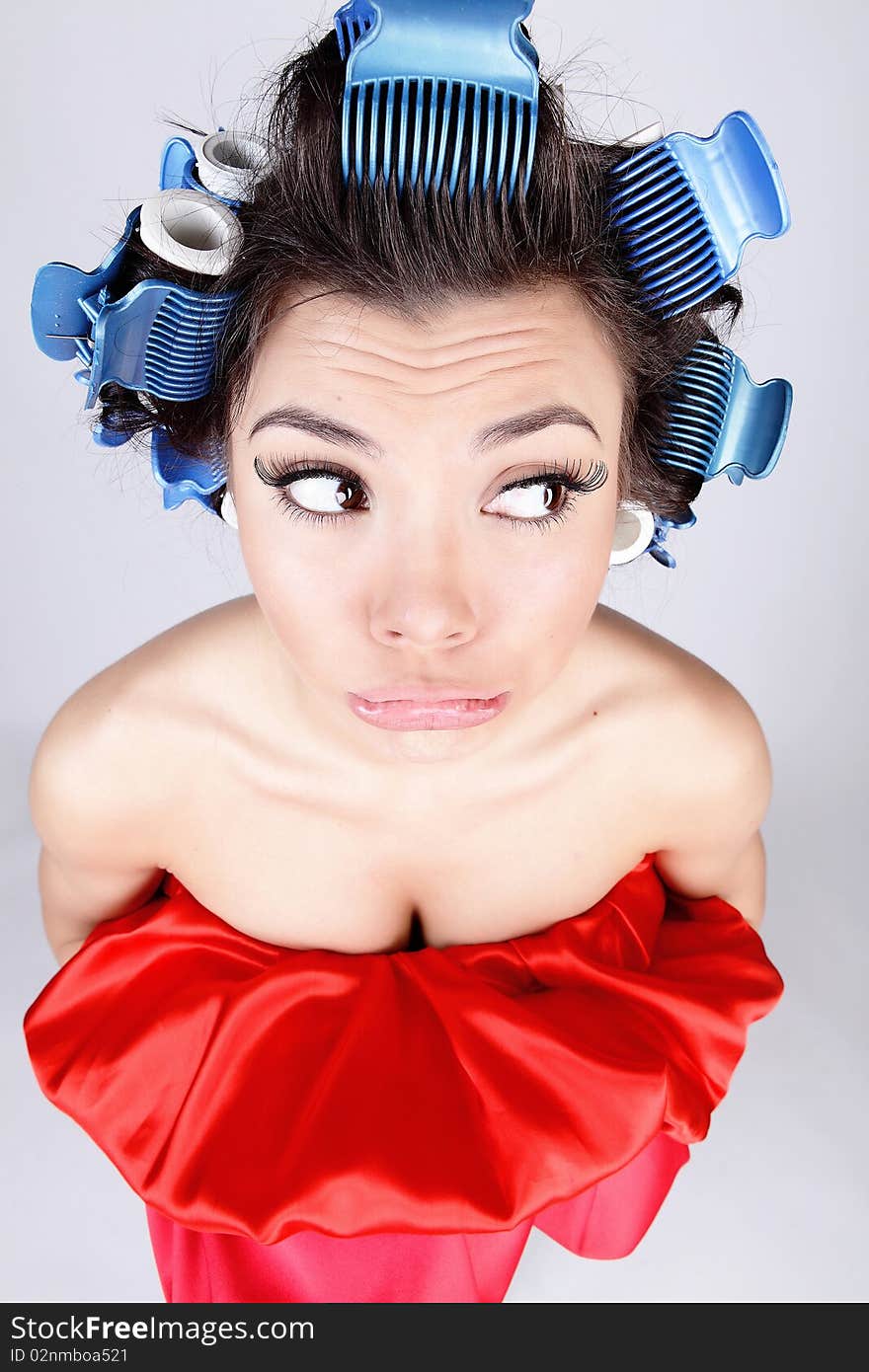 Emotional Girl with hair-curlers on her head. Photo.