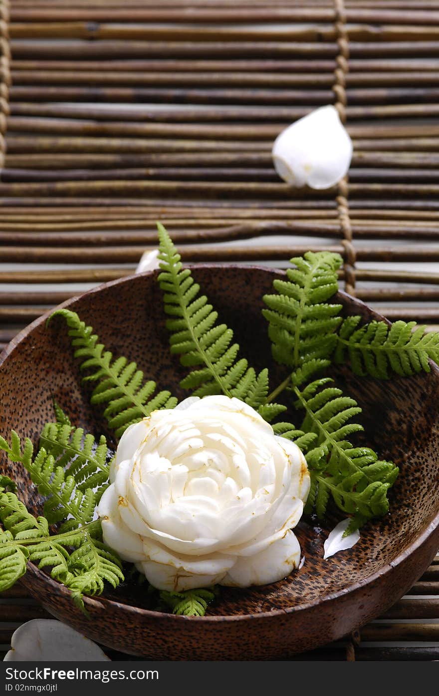 Bowl of camellia blossoms on bamboo mat. Bowl of camellia blossoms on bamboo mat