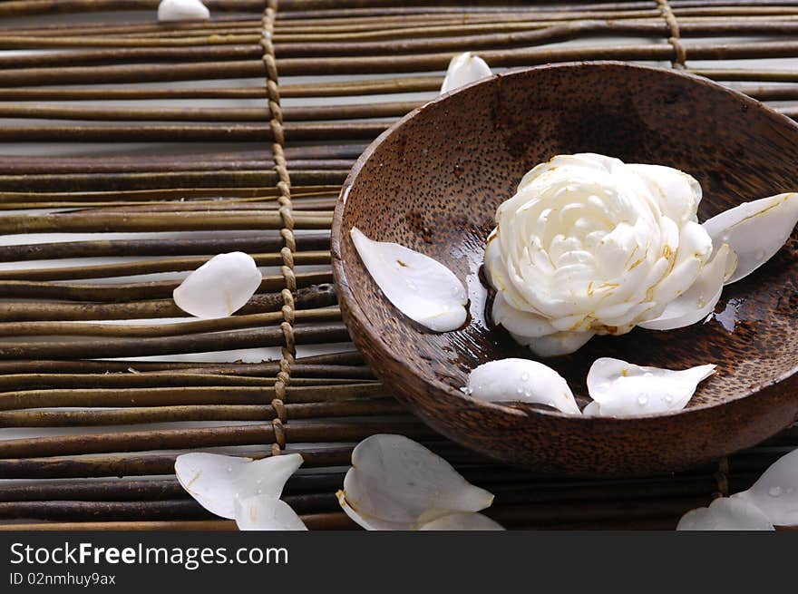 Bowl of camellia blossoms with petal on bamboo mat. Bowl of camellia blossoms with petal on bamboo mat