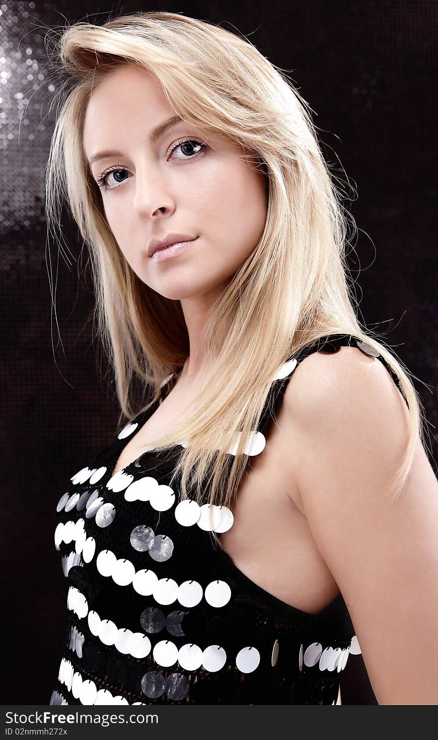 Attractive blond beauty posing in dark background.