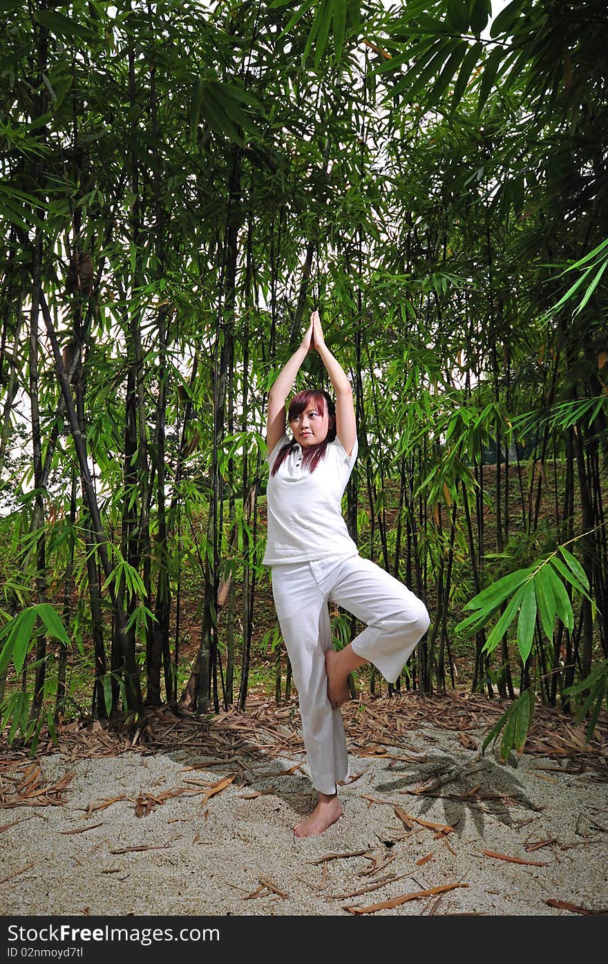 Asian Woman Practising Yoga In Woods