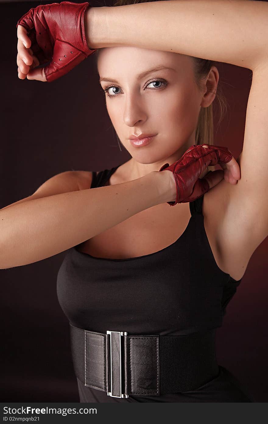 Attractive posing blonde in a red sport gloves. Fashion photo.