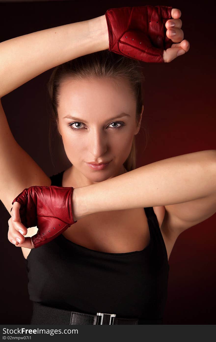 Attractive posing blonde in a red sport gloves. Fashion photo.