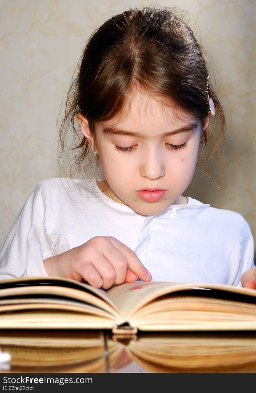 Young schoolgirl is reading book. Young schoolgirl is reading book