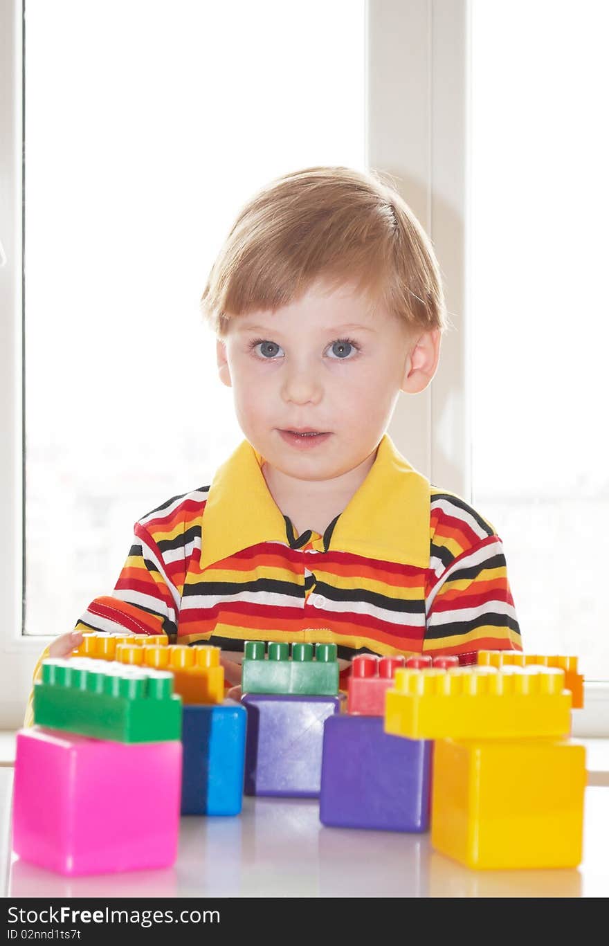 The beautiful little boy poses on a light background. The beautiful little boy poses on a light background