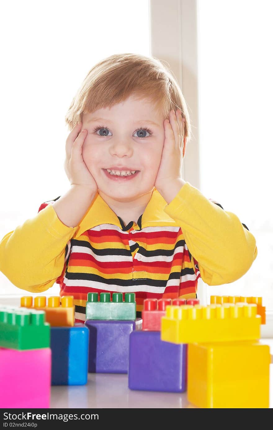 The beautiful little boy poses on a light background. The beautiful little boy poses on a light background