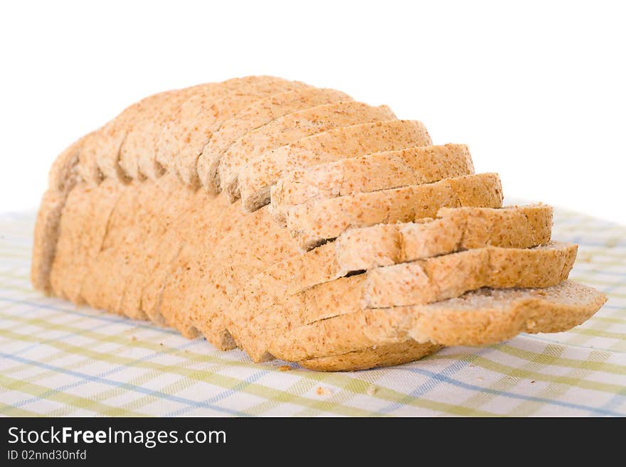 Fully sliced wholemeal bread placed on linen cloth in green and blue stripes, studio shoot. Fully sliced wholemeal bread placed on linen cloth in green and blue stripes, studio shoot