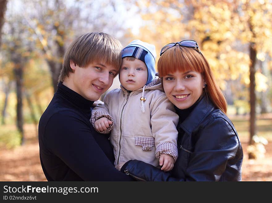 Happy family on walk in park in the autumn