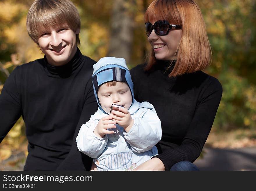 Happy family on walk in park in the autumn