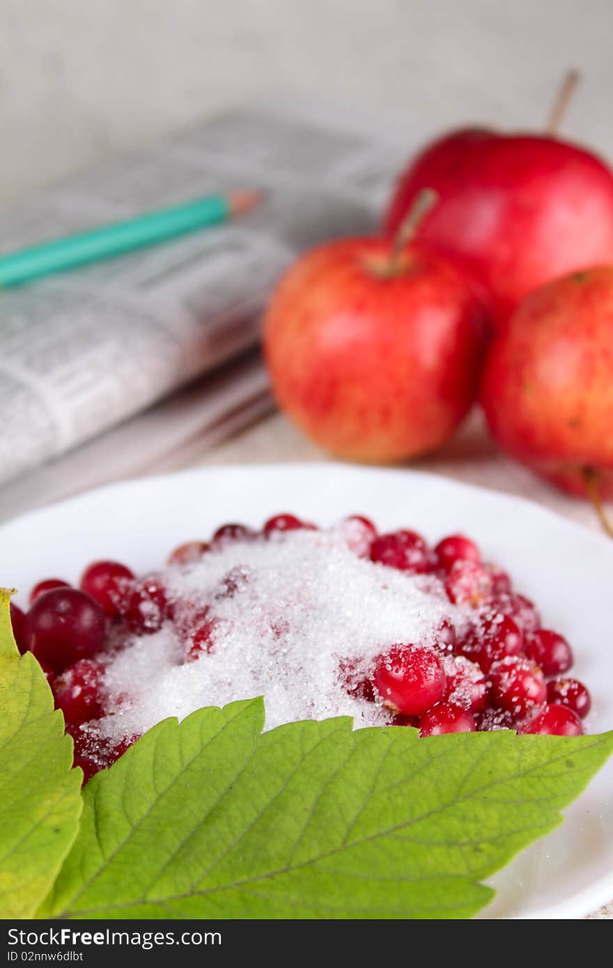 Plate of a cowberry sprinkled with sugar removed close up against a linen napkin. Plate of a cowberry sprinkled with sugar removed close up against a linen napkin