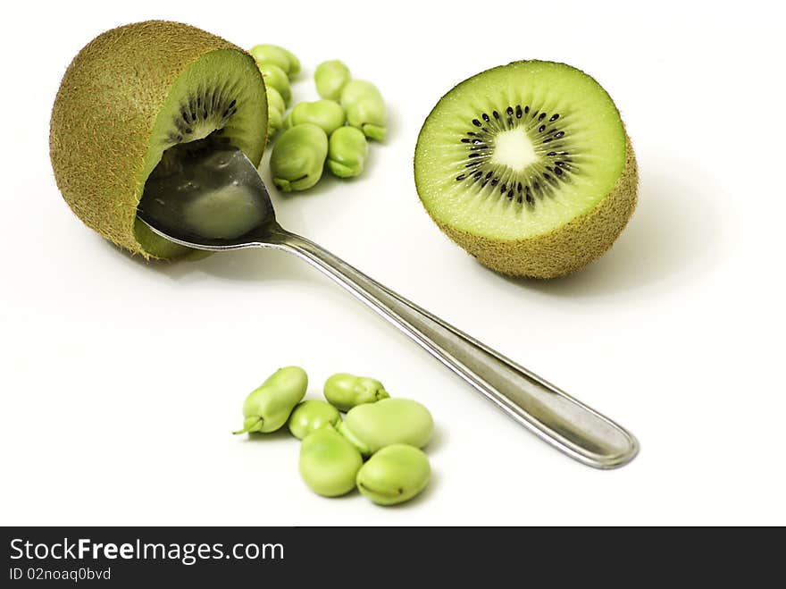 Presentation of kiwi game with a spoon, on a white background adorned with beans. Presentation of kiwi game with a spoon, on a white background adorned with beans.