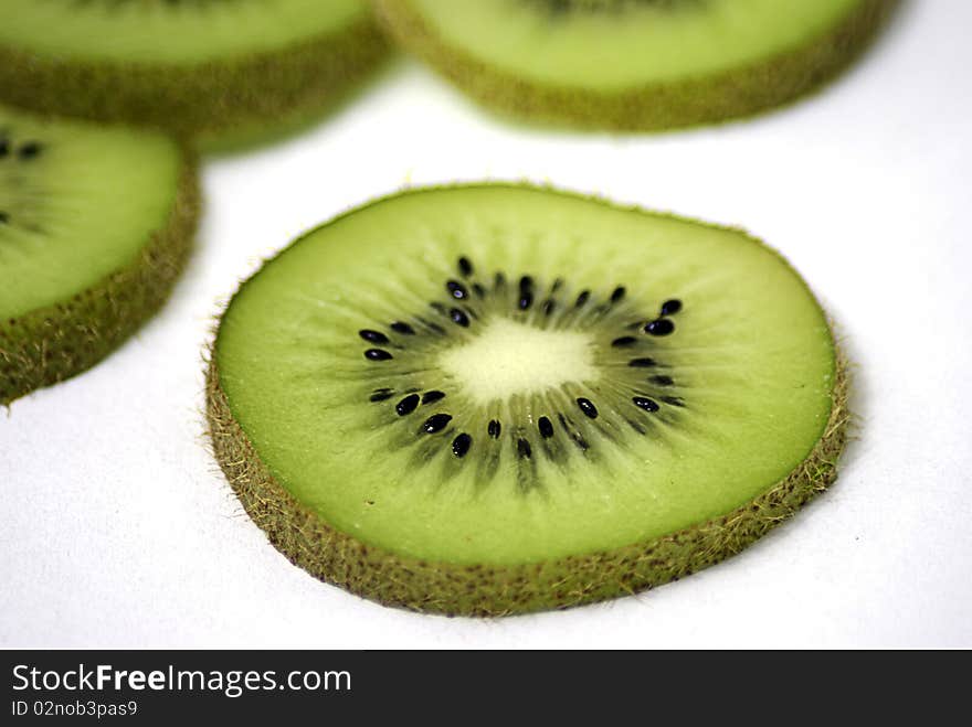 Kiwi slices overlapping on a white background