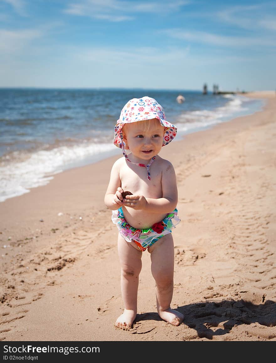 Image of the happy baby on the beach