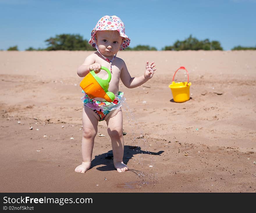 Image of the happy baby playing on the beach