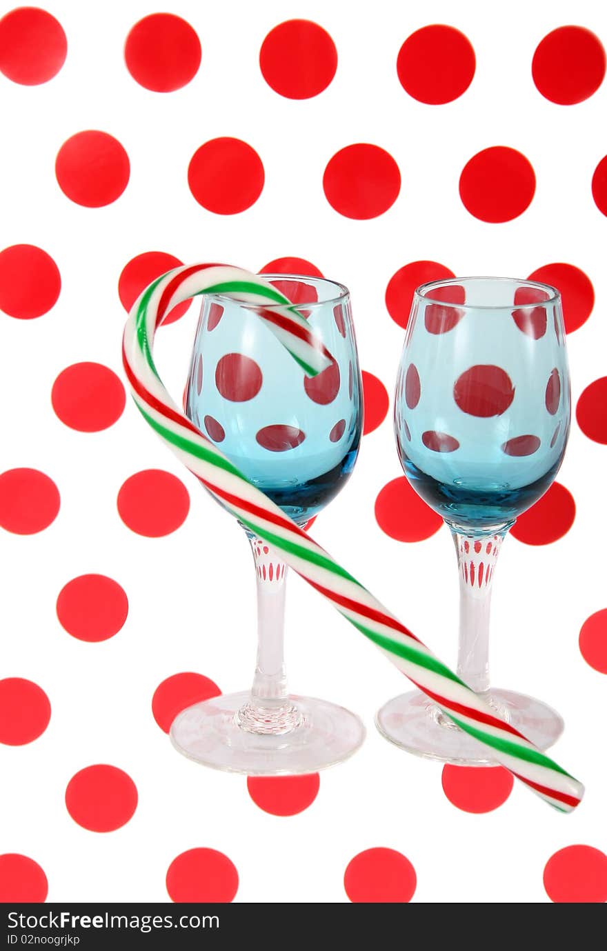 Two blue stained glasses with a candy cane on a polkadot background