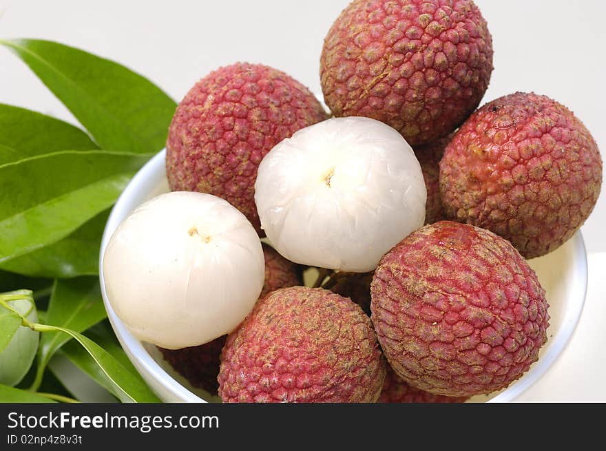 Bowl of Lychees and two peeled with leaf. Bowl of Lychees and two peeled with leaf