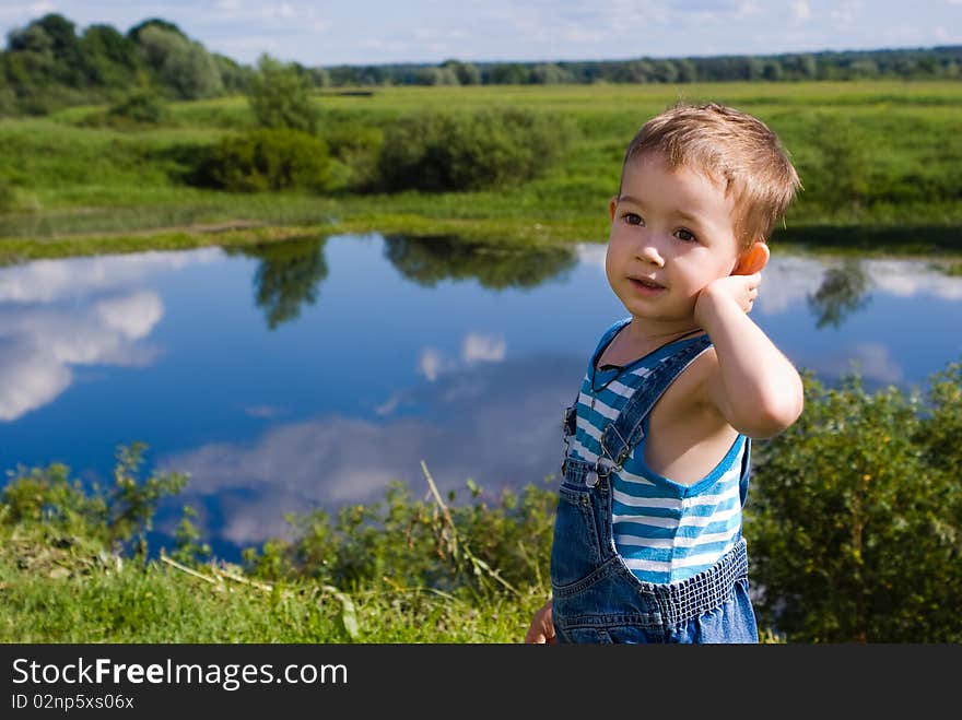 Little boy on a summer lake background. Little boy on a summer lake background