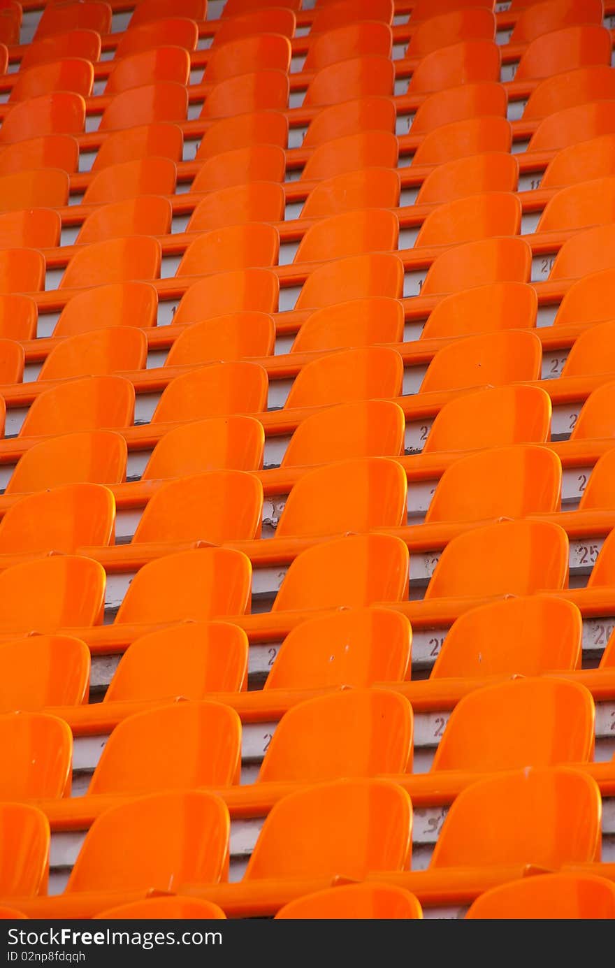 Orange empty stadium seats in a row